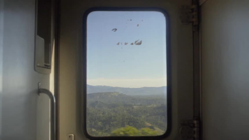 Hills outside of the window of a moving train
