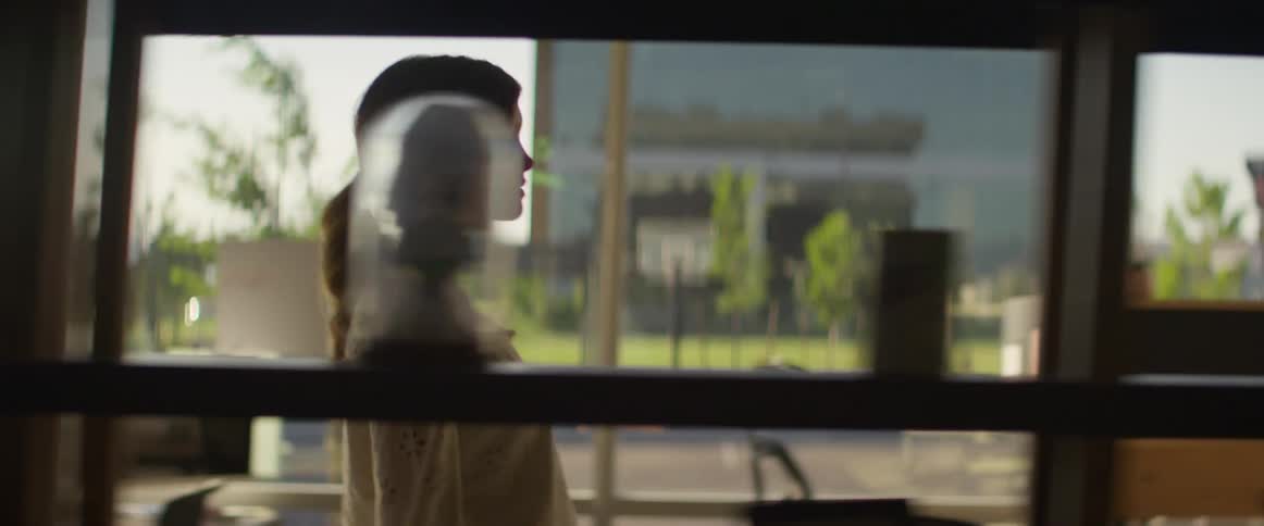 A woman walks down a hallway in an office building