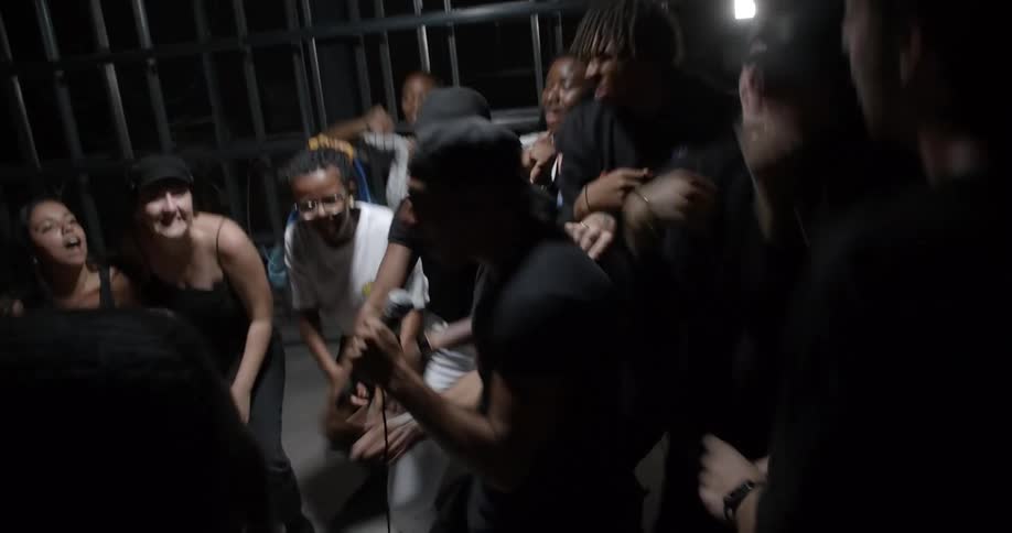 A group of people jump and cheer as a man sings
