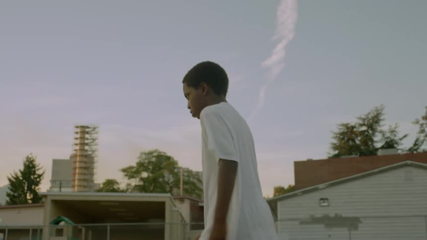 A boy walks along a neighborhood street by himself