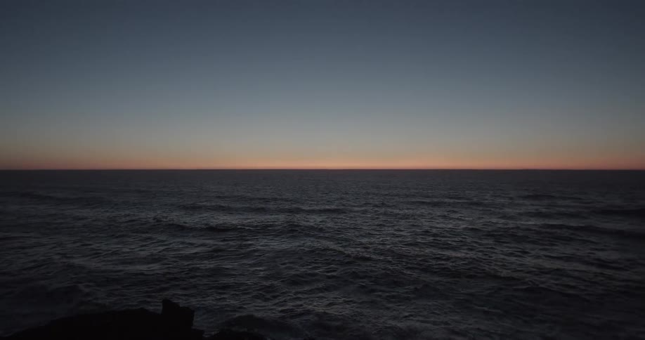 Waves move over the ocean at dusk