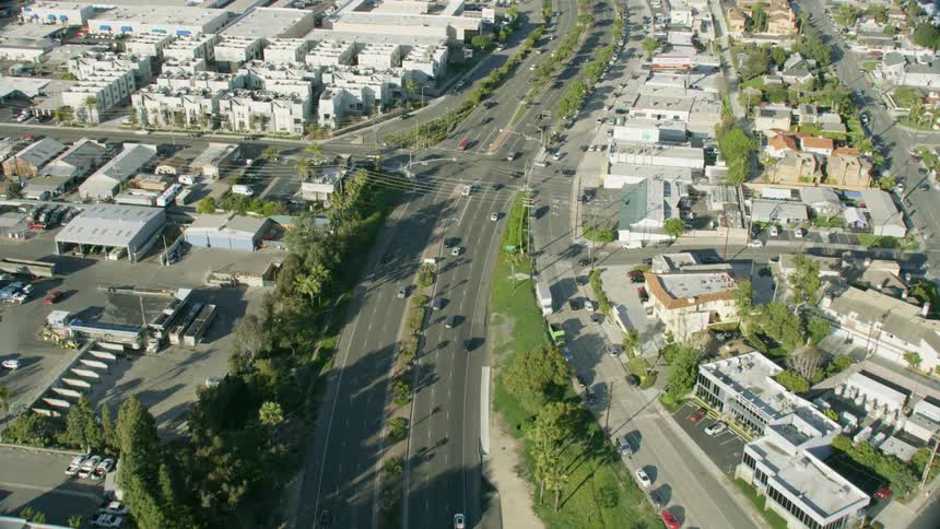 Cars driving down a street in a city