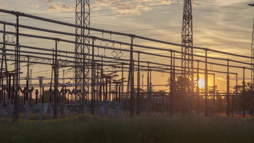 The sun setting over a power plant