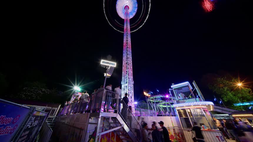 An amusement park at night with people and rides