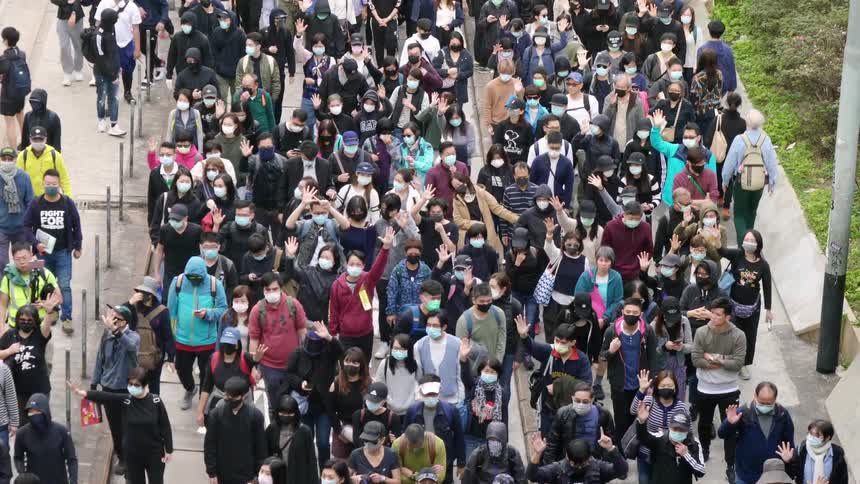 A crowd of asian people of all ages walk down a large sidewalk