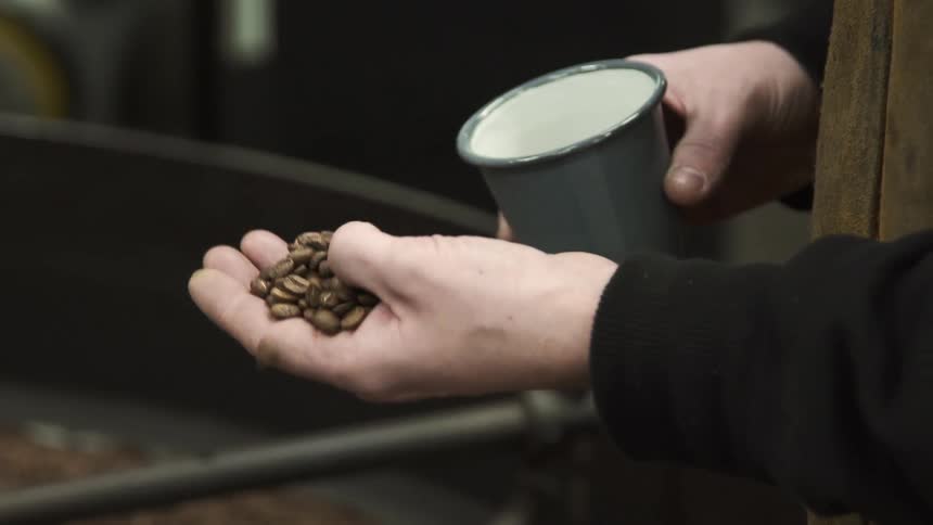 A man pouring coffee beans in to his hand