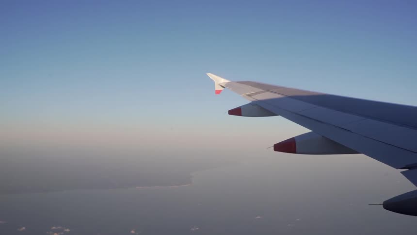 The wing of a plane as it is in flight