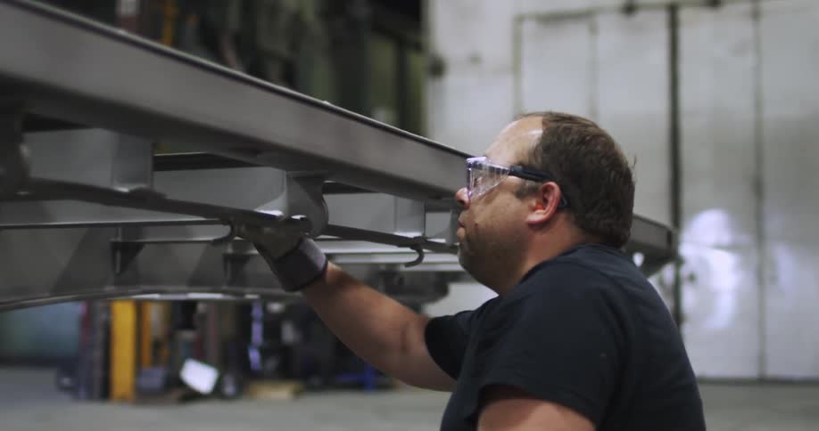 A worker hammers on a piece of metal