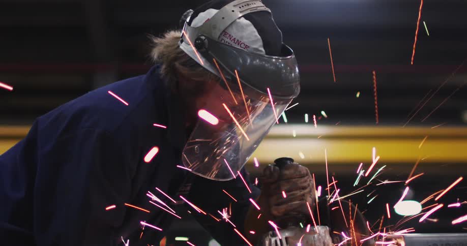 A man wearing a safety mask is using a power tool