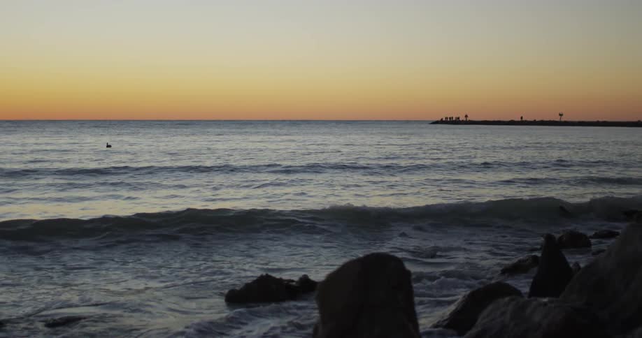 Waves washing over rocks at sunset