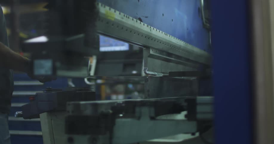A man is operating a machine in a warehouse