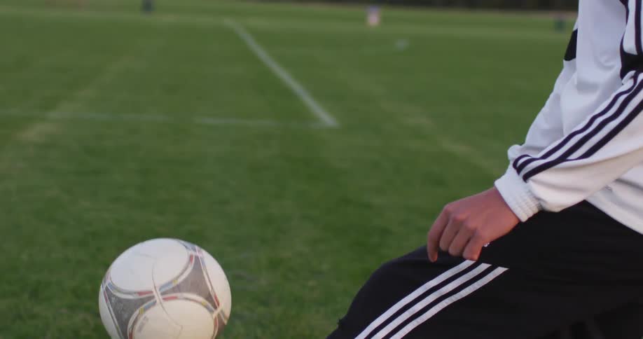 A man is kicking a football around on a field