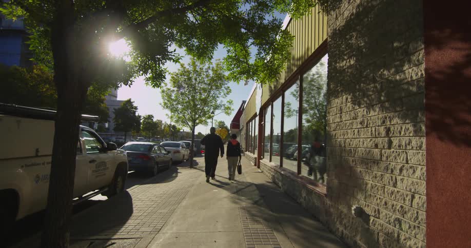 People walking down the sidewalk in an urban area