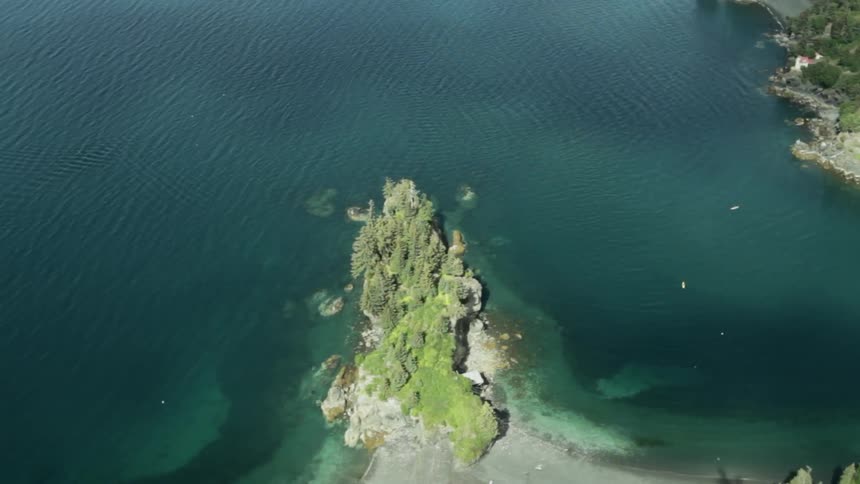 Rocky land lies beside clear calm water