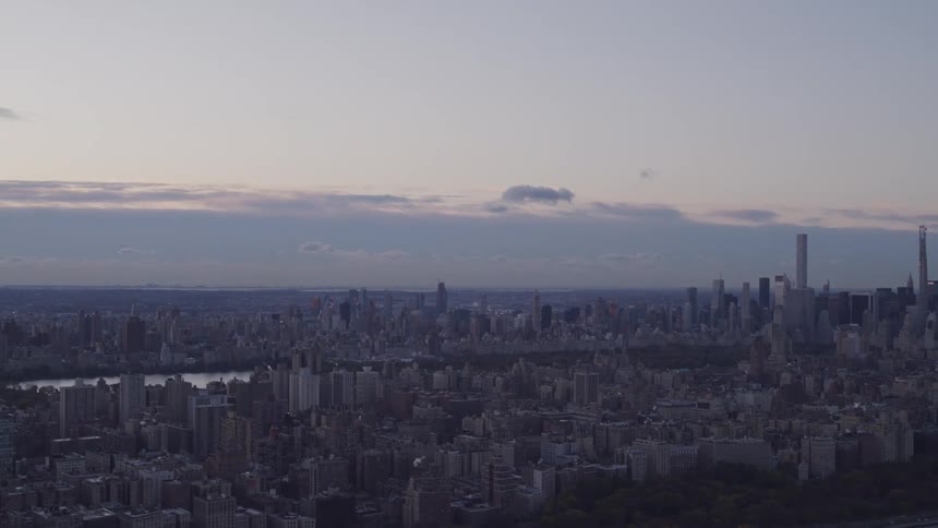 Buildings in a city sit as dusk falls