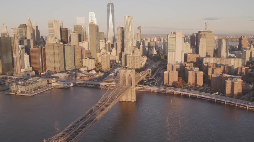 A bridge crosses a river next to a large city