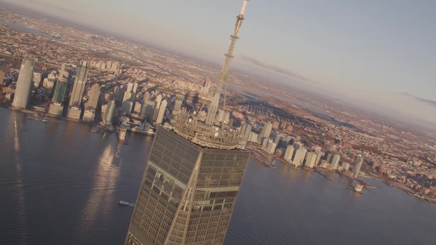 A tall skyscraper looming over a body of water in a city