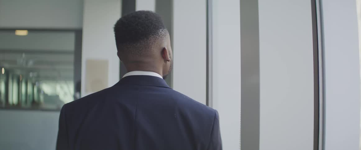 A man stands and looks out the window