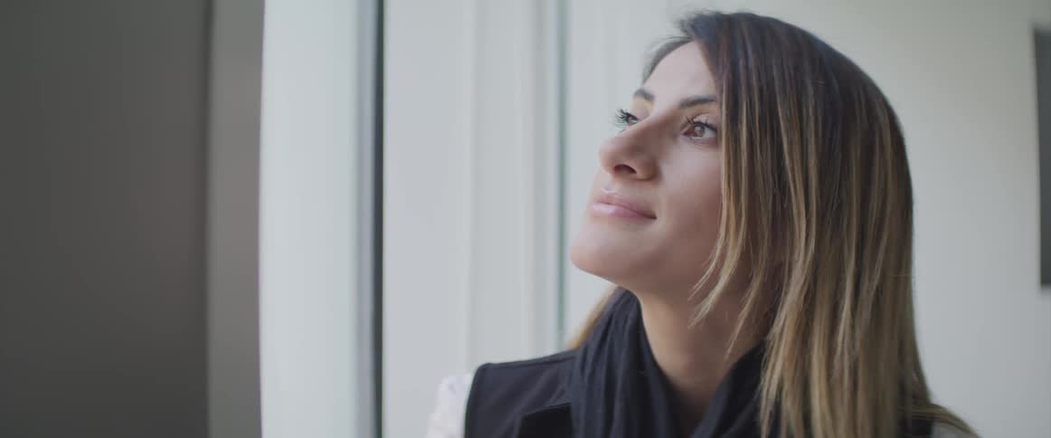 Brunette woman looks out the window