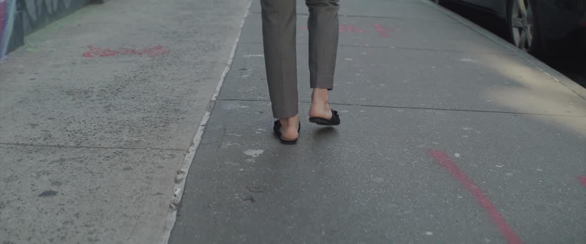 A person is walking on the sidewalk