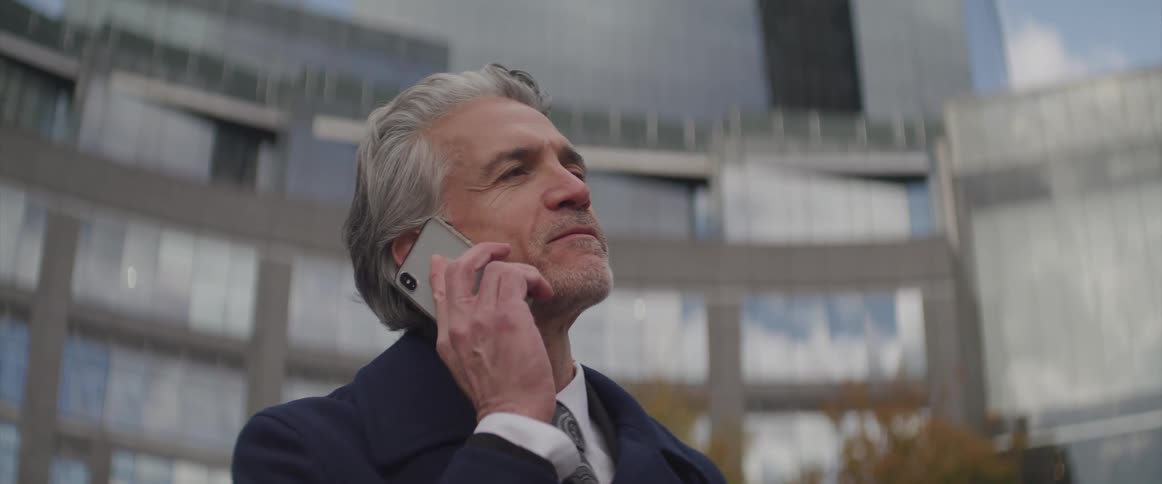 A man stands outside and talks on his cell phone