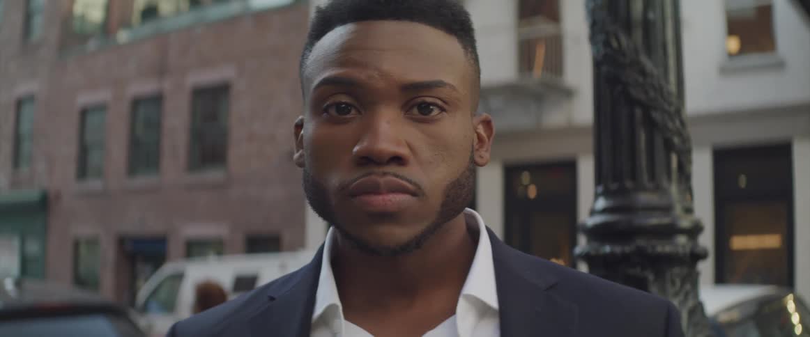 Black businessman turns his head and looks at the camera in the city