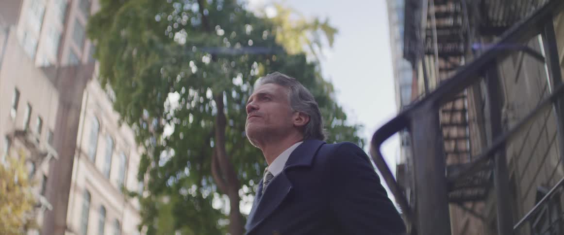 A man stands outside of a city building