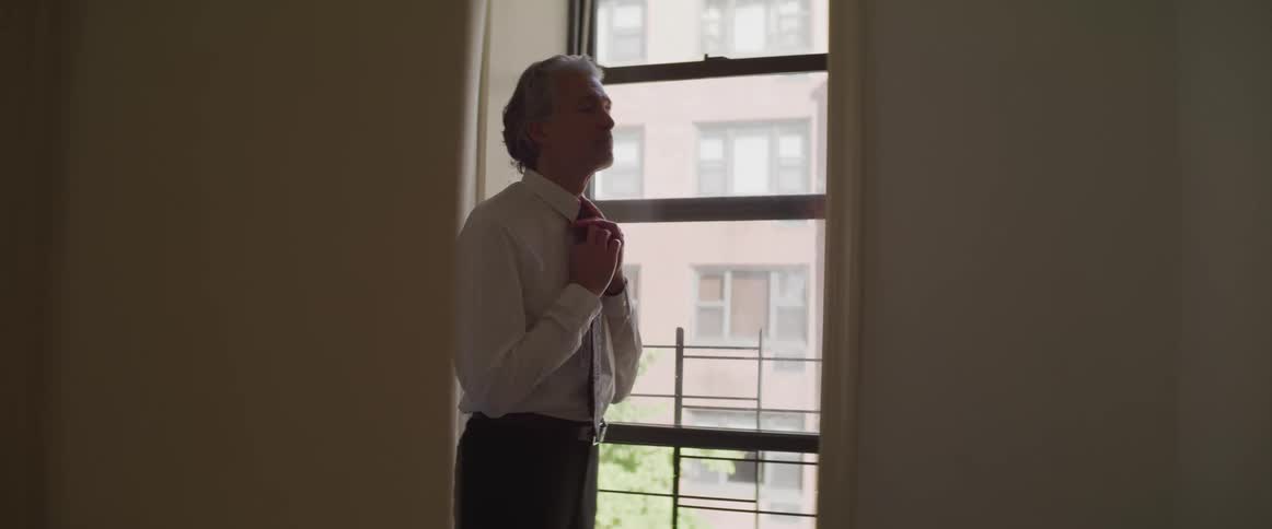 The man adjusts his tie