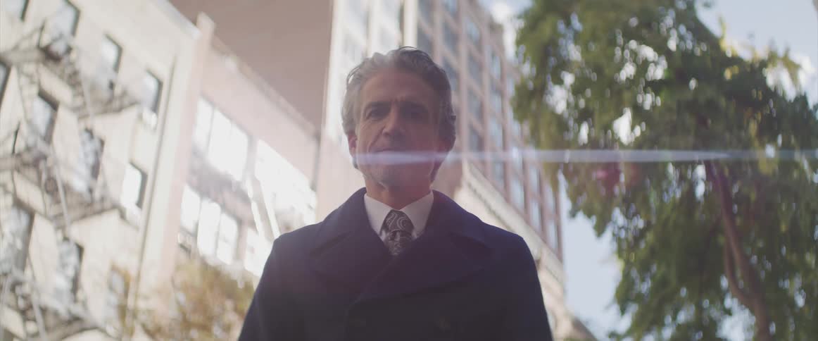 A man stands outside in a suit