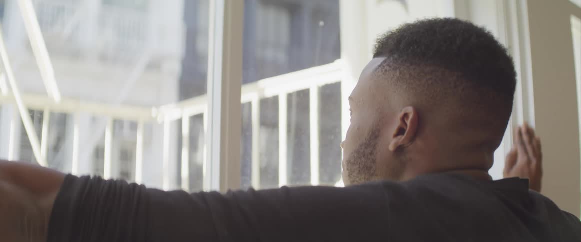 A man gazing out of a window on a sunny day