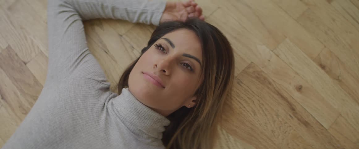 A woman lays on the hardwood floor