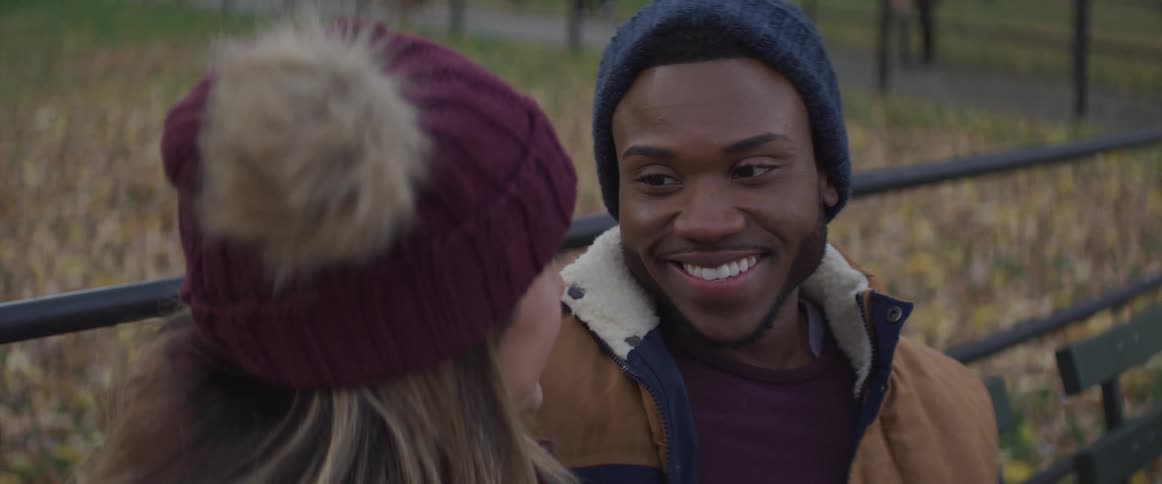 A man looks at the woman sitting next to him and smiles