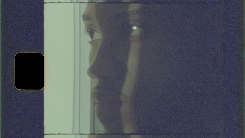 Black man looks out the window