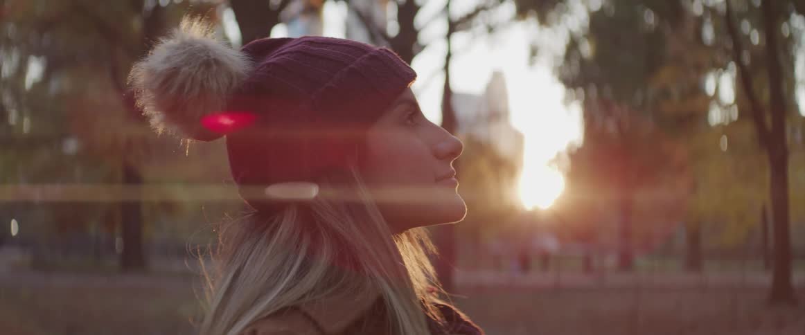 A woman stands outside and closes her eyes