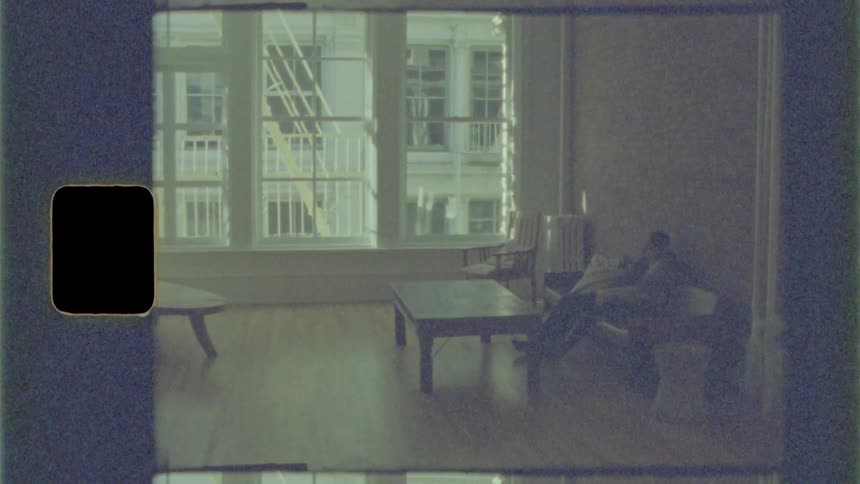 Black man and white woman sitting on the sofa cuddle each other in the living room at home