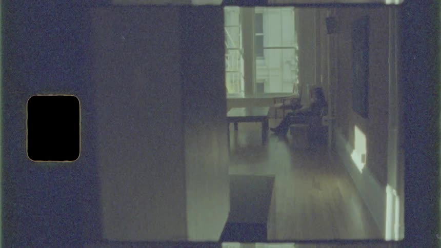 Person sits in a chair in front of a coffee table and taps his foot on the floor