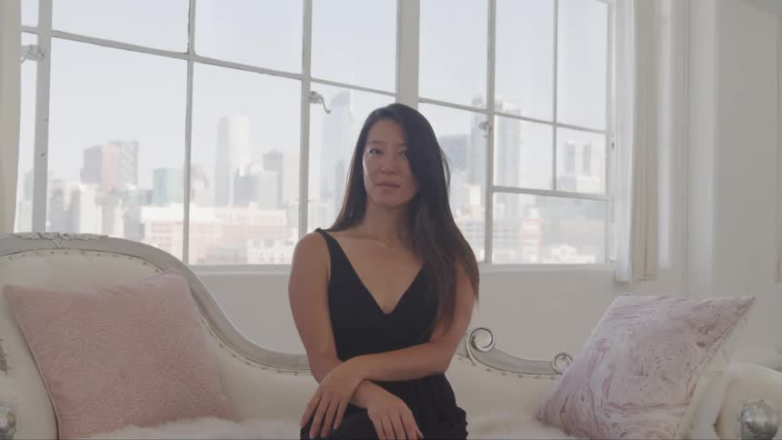 A woman sits on a couch inside
