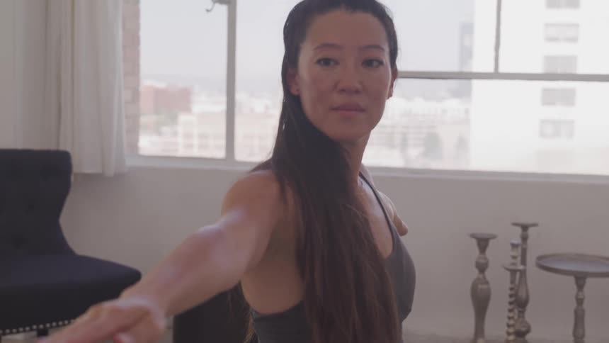 Asian woman works out in the living room at home