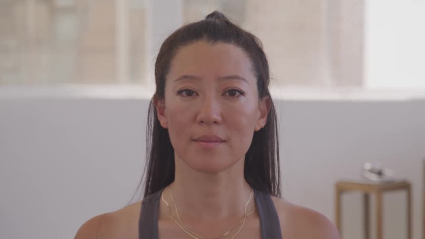 Asian woman does yoga in the living room