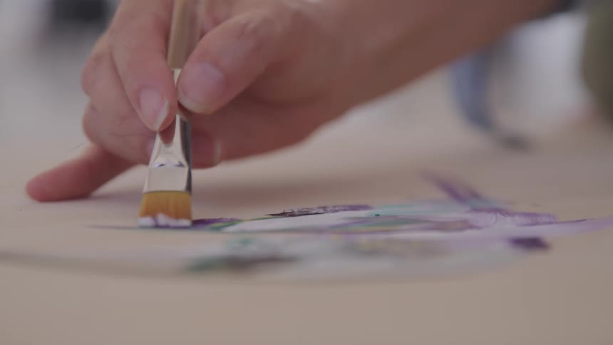 Someone paints on the canvas