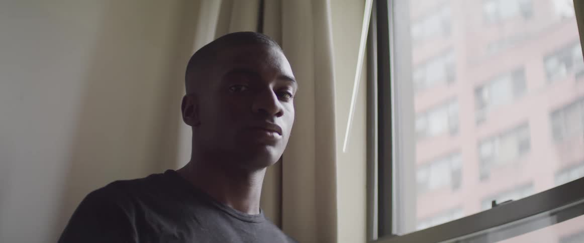 A man stands by the window