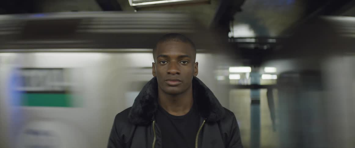 A man standing with a train moving in the background