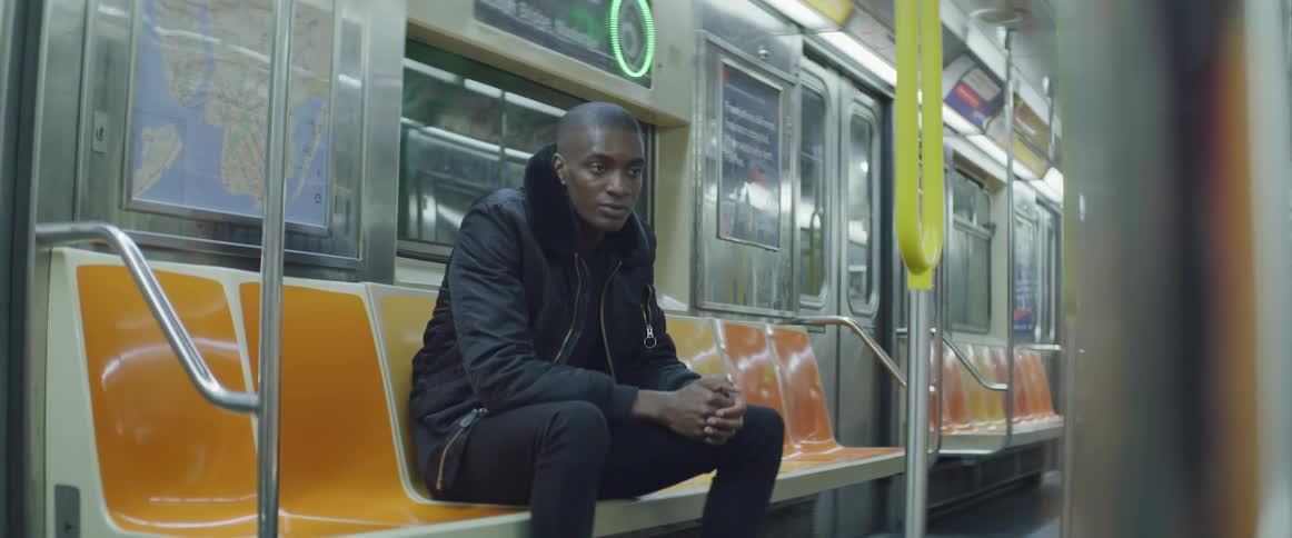 A man sits riding the subway train