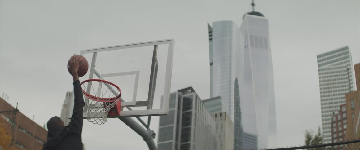 A man attempts to dunk a basketball but misses the net