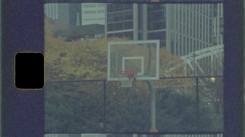 A basketball hoop with trees and buildings in the background