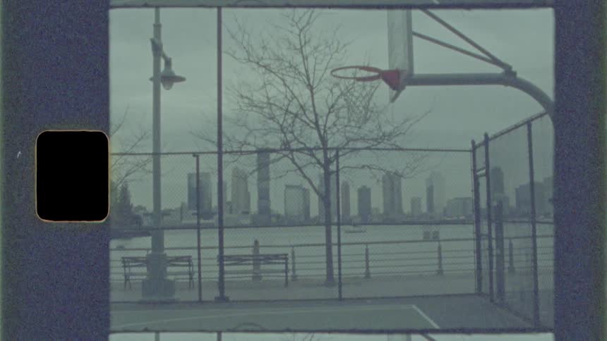 A basket ball court with the city skyline in the distance