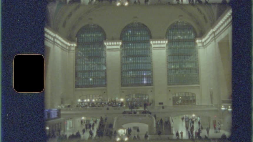 Passengers walk through central transit station with arrivals and departures display
