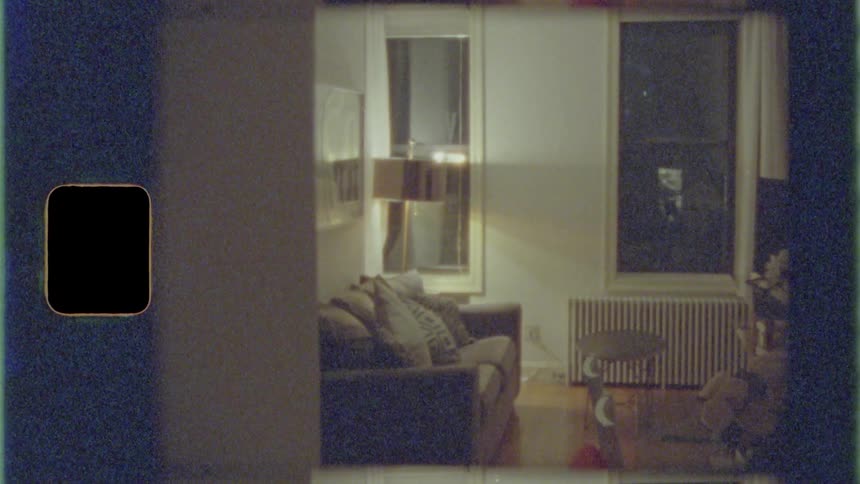Lamp lights living room near windows and radiator at night