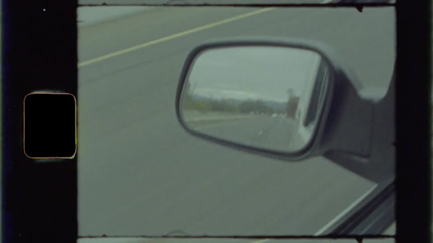 A car rear view mirror and the street