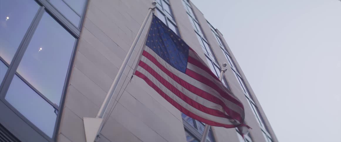 A flag on the side of a building blows in the breeze